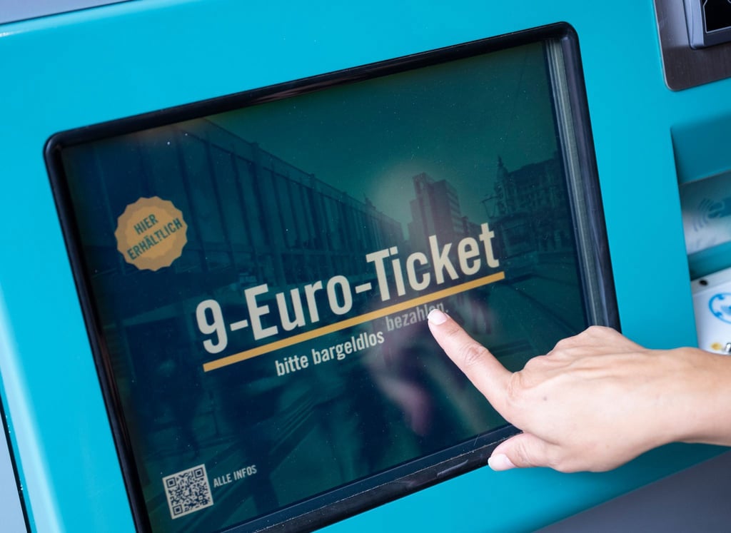 Eine Frau zieht sich an einem Fahrschein-Automaten ein 9-Euro-Ticket.