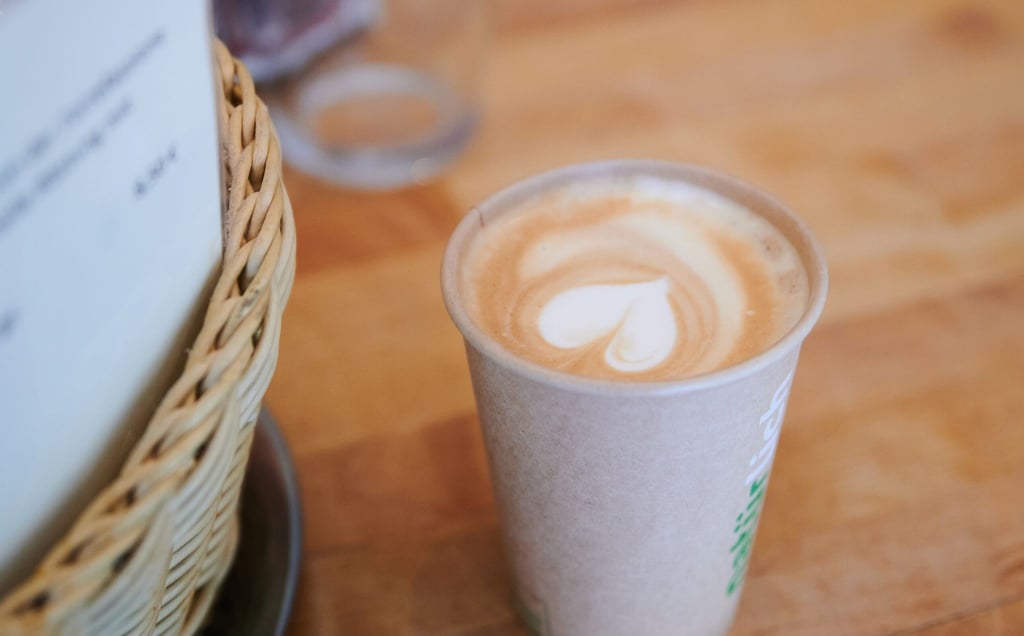 Ein Cappuccino mit Herzform im Milchschaum, den ein Mitarbeiter eines Cafés in Berlin-Mitte zubereitet hat, steht auf einem Tisch.