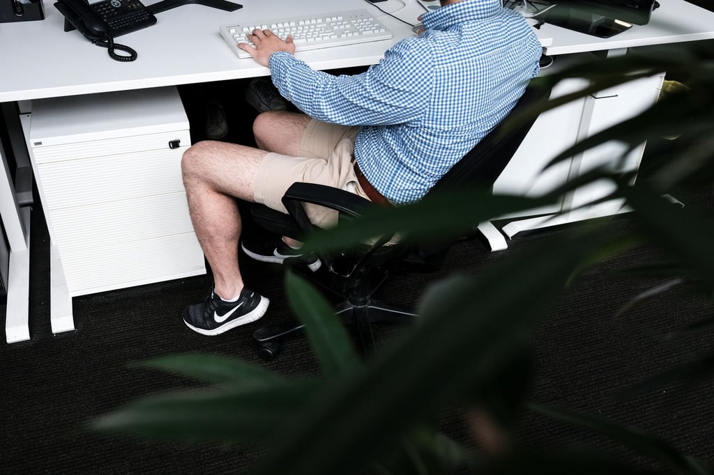 Ein Mann sitzt mit kurzer Hose an seinem Arbeitsplatz. Beschert uns Corona eine neue Lässigkeit?