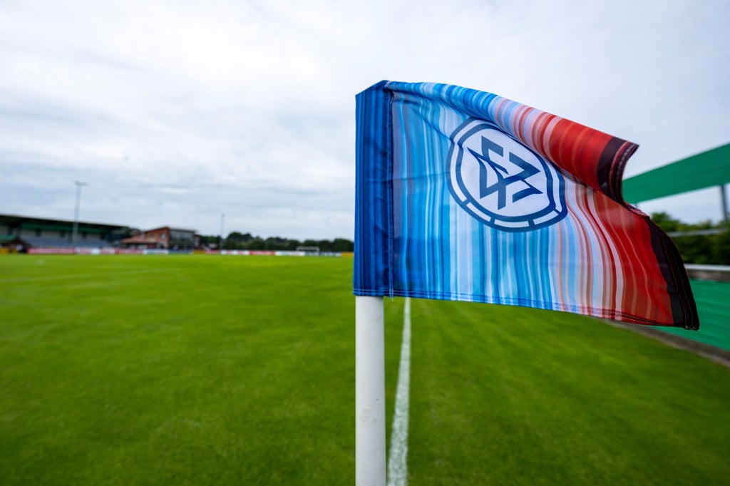 Die Eckfahne mit DFB-Logo und und "Warming Stripes" (Klimastreifen) weht im Wind.