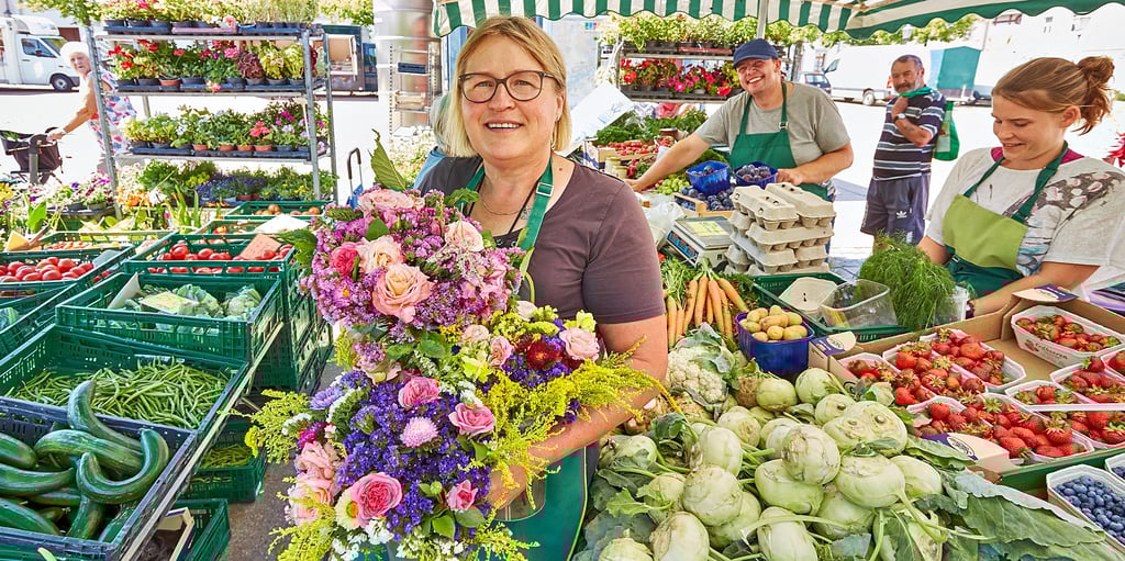 Kerstin Kuhlbrodt (Mitte) und ihr Team verkaufen an ihrem Stand Blumen, Kräuter, Obst und Gemüse.