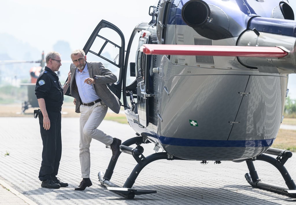 Armin Schuster steigt aus einem Polizeihubschrauber aus.