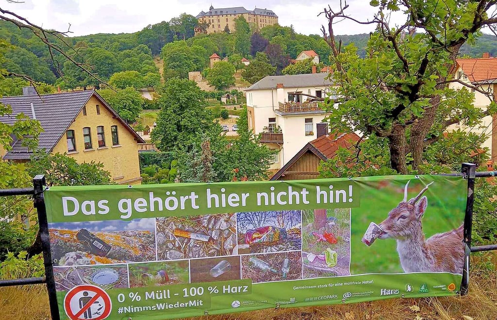 An der Teufelsmauer in Blankeburg zwischen Großmutter und Großvater weist eines der Banner Wanderer auf die Müll-Problematik im Harz hin.