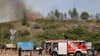 Ein Flächenbrand auf einer ehemaligen Halde im Industriegebiet SKET in Magdeburg wird durch die Feuerwehr und einen Hubschrauber der Polizei gelöscht.