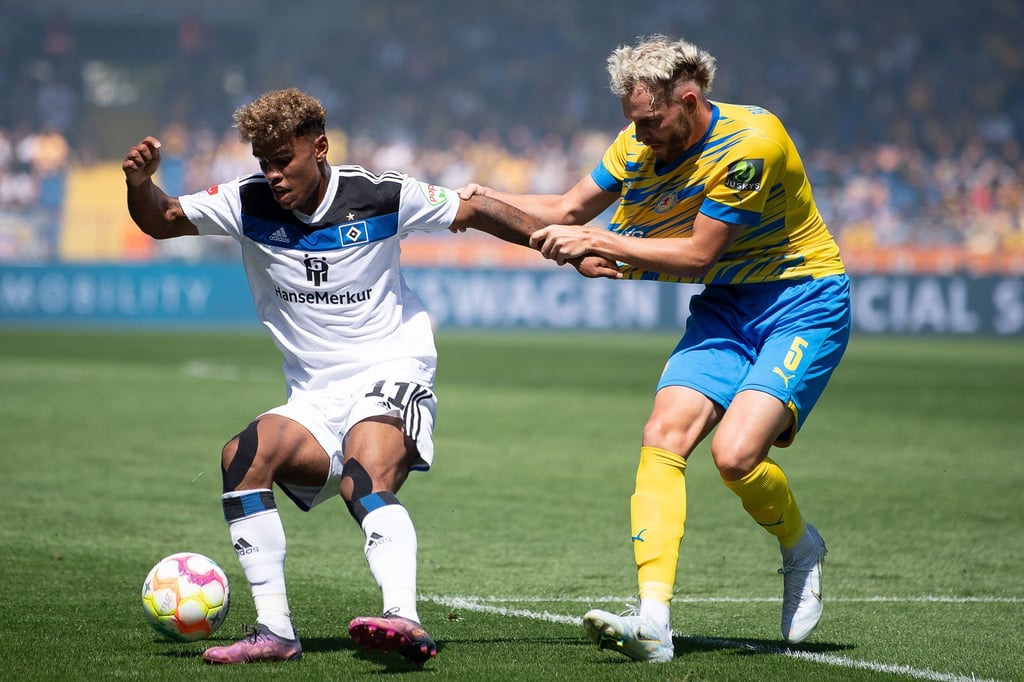 Hamburgs Ransford Königsdörfer (l) schirmt im Zweikampf den Ball vor Braunschweigs Brian Henning ab.