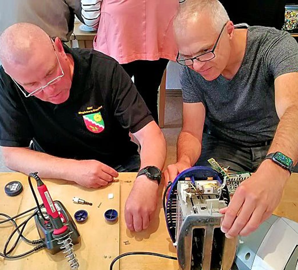 Uwe Fischer und Enrico Ebel reparieren einen Toaster.