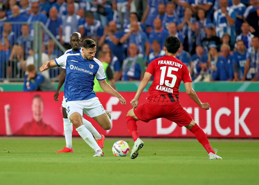 Sammelt weiter fleißig Erfahrung im Profi-Fußball: Tim Sechelmann (l.) vom 1. FC Magdeburg, hier im Duell mit Eintracht Frankfurts Bundesligaspieler Daichi Kamada.
