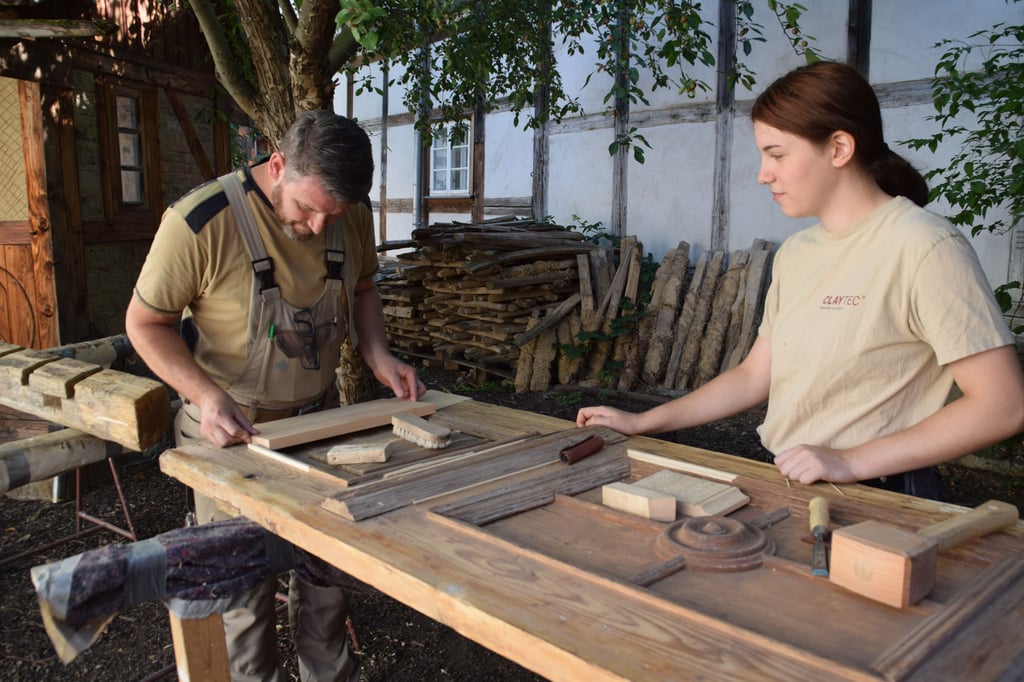 Tischler Norman Schur und Paula Gödecke von der Jugendbauhütte restaurieren eine Renaissance-Flügeltür.