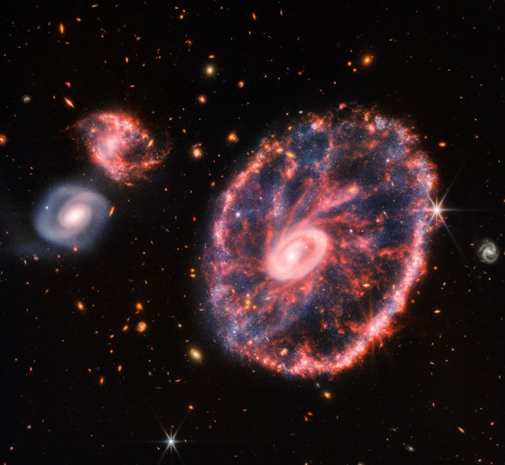 Dieses von der NASA zur Verfügung gestellte Handout-Foto zeigt eine große, rosa-blau gesprenkelte Galaxie, die einem Rad mit einem kleinen, inneren Oval ähnelt.