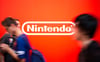 Besucher auf der Gamescom laufen an dem Nintendo-Logo vorbei.