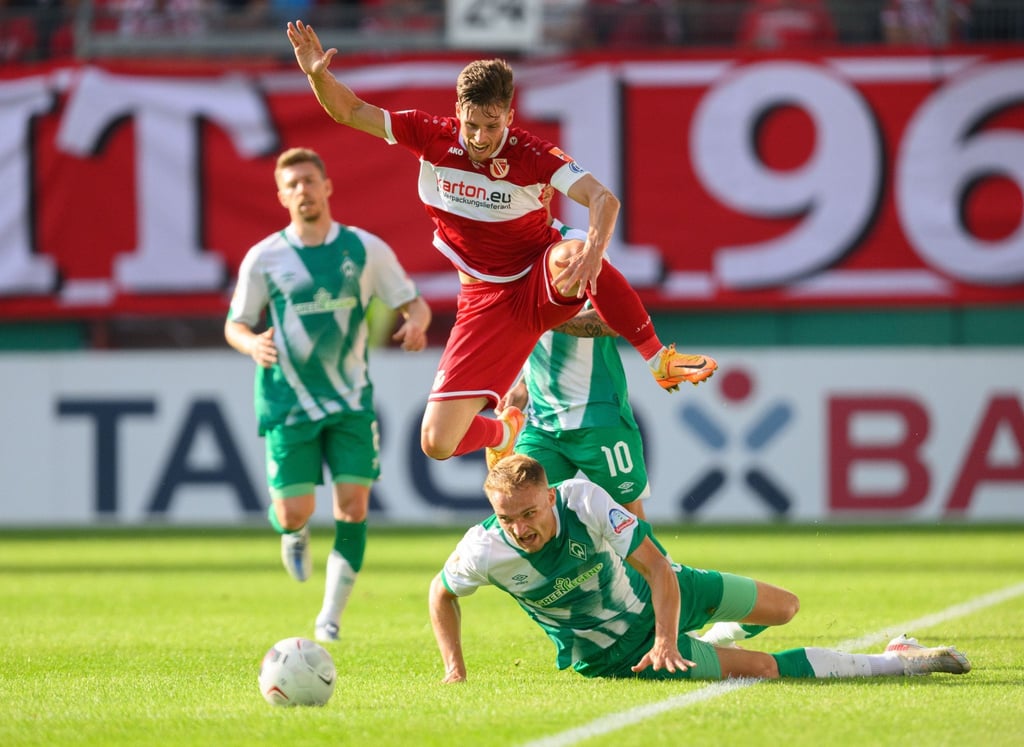 Der Cottbuser Axel Borgmann springt über Bremens Amos Pieper.