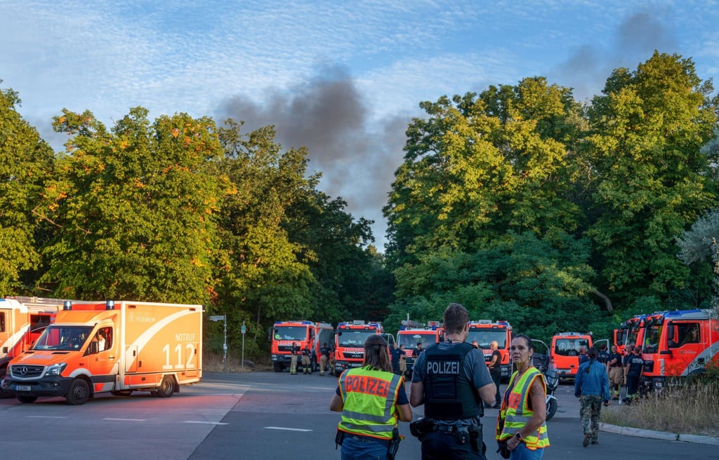 Polizeibeamte und Feuerwehrfahrzeuge stehen am Kronprinzessinnenweg in Berlin.