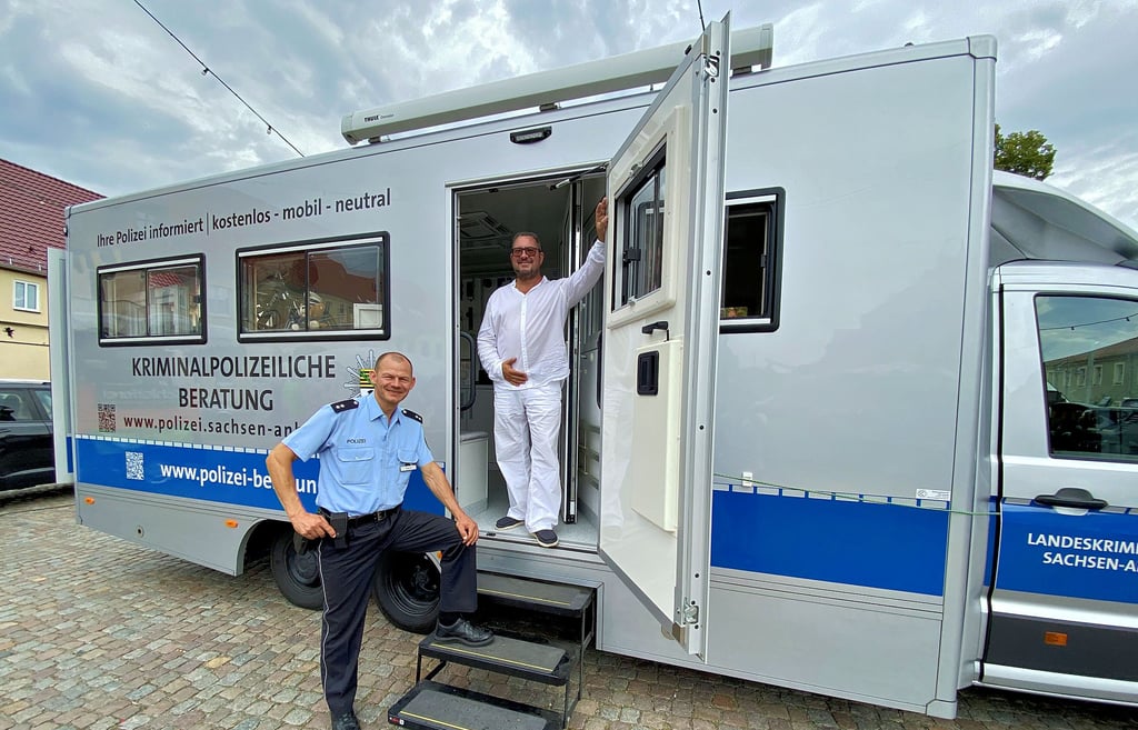 Tobias Trabitz vom Revier Wittenberg und Jörg Hubatschek vom Landeskriminalamt beraten auf dem Jessener Markt im Sicherheitsmobli des LKA.
