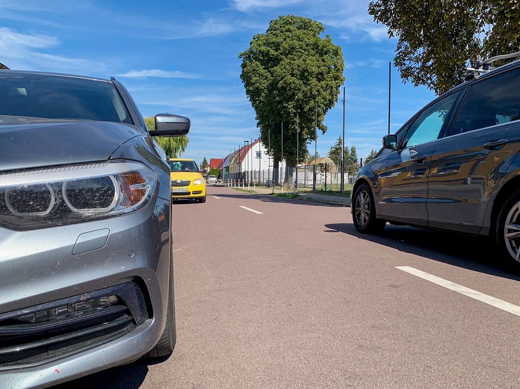 Die Szene in Radegast zeigt: Ein Van (r.) passiert ein parkendes Auto (l.) am Straßenrand, das gelbe Auto im Gegenverkehr (M.) muss warten.