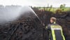 Ein Feuerwehrmann löscht einen Brand im Großen Moor im Landkreis Gifhorn.