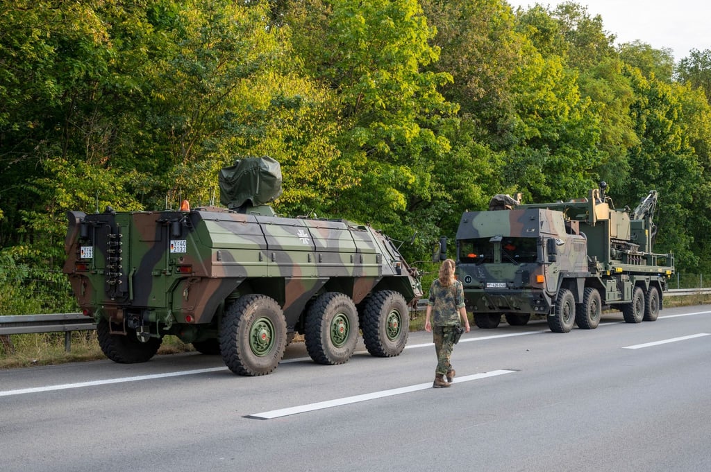 Spezialfahrzeuge der Bundeswehr stehen in der Nähe der Brandstelle.