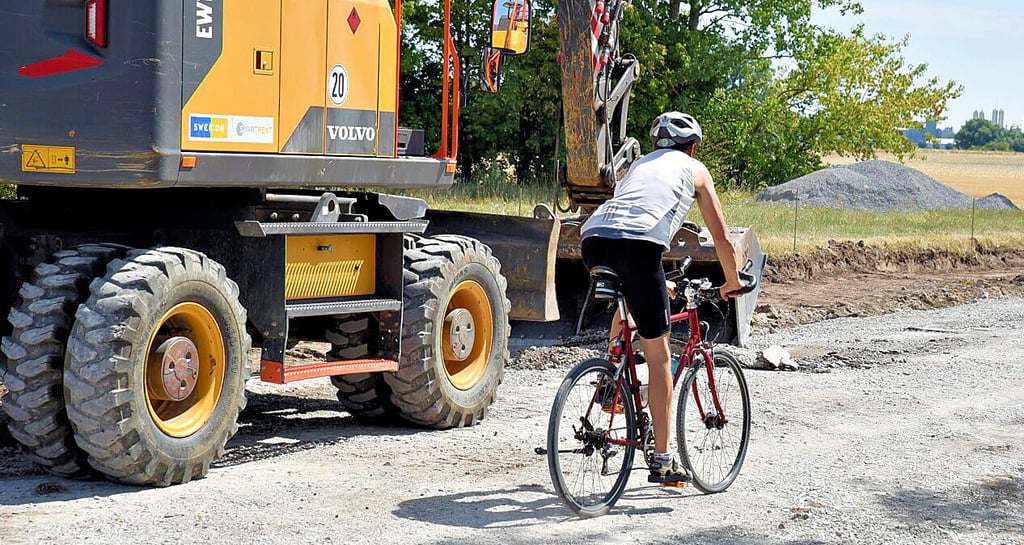 Ein Mann radelt tagsüber einfach über die Baustelle.