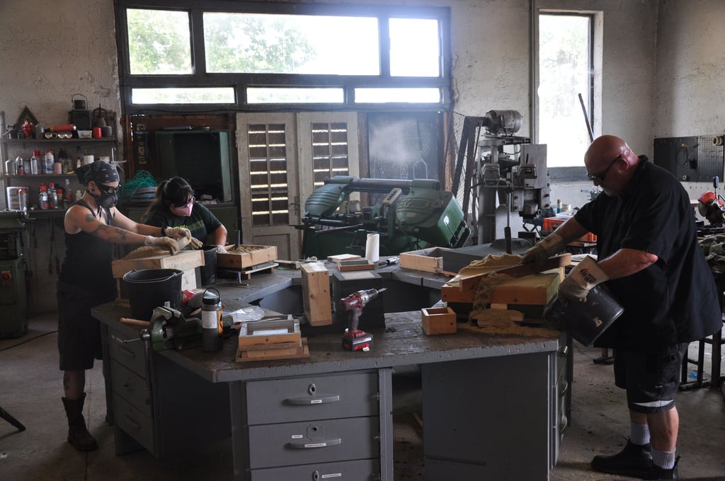 Kurt Dyrhaug (rechts) bereitet gemeinsam mit zwei Künstlerinnen aus den USA in einer Werkstatt im Atelier in Hilmsen Formen zum Eisengießen vor.