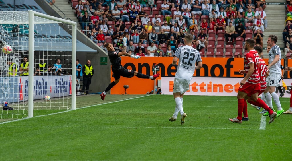 Augsburgs Torwart Rafal Gikiewicz (l) kann dem Ball beim 0:2 nur noch hinterherschauen.
