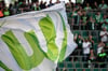 Das Logo vom VfL Wolfsburg ist auf einer Flagge vor Zuschauern zu sehen.