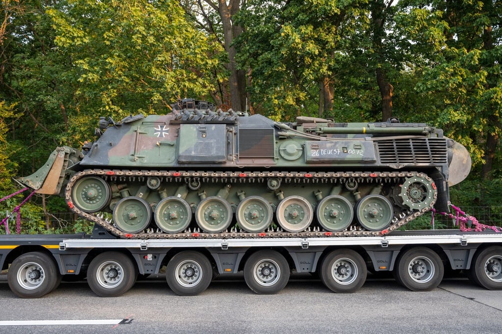Ein Pionierpanzer Dachs der Bundeswehr steht in der Nähe der Brandstelle.