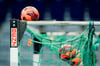 Spielbälle liegen im Netz eines Handball-Tors.