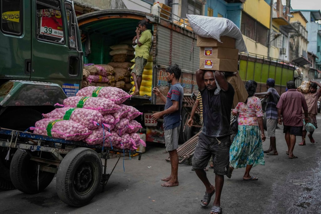 Ein Mann in Colombo mit einer Ladung importierter Lebensmittel auf einem Markt.