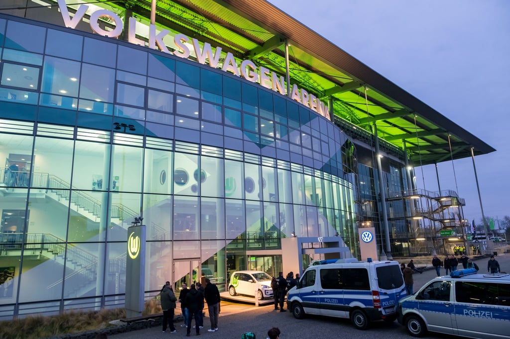 Polizeifahrzeuge stehen vor der Volkswagen Arena.