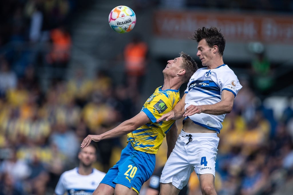 Braunschweigs Lion Lauterbach (l) im Kopfballduell mit Darmstadts Christoph Zimmermann.