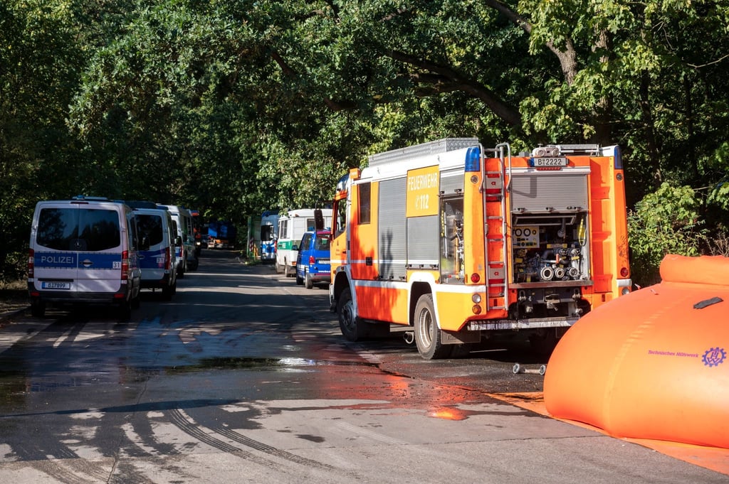 Feuerwehrautos und Fahrzeuge der Polizei stehen in der Nähe der Brandstelle am Sprengplatz.