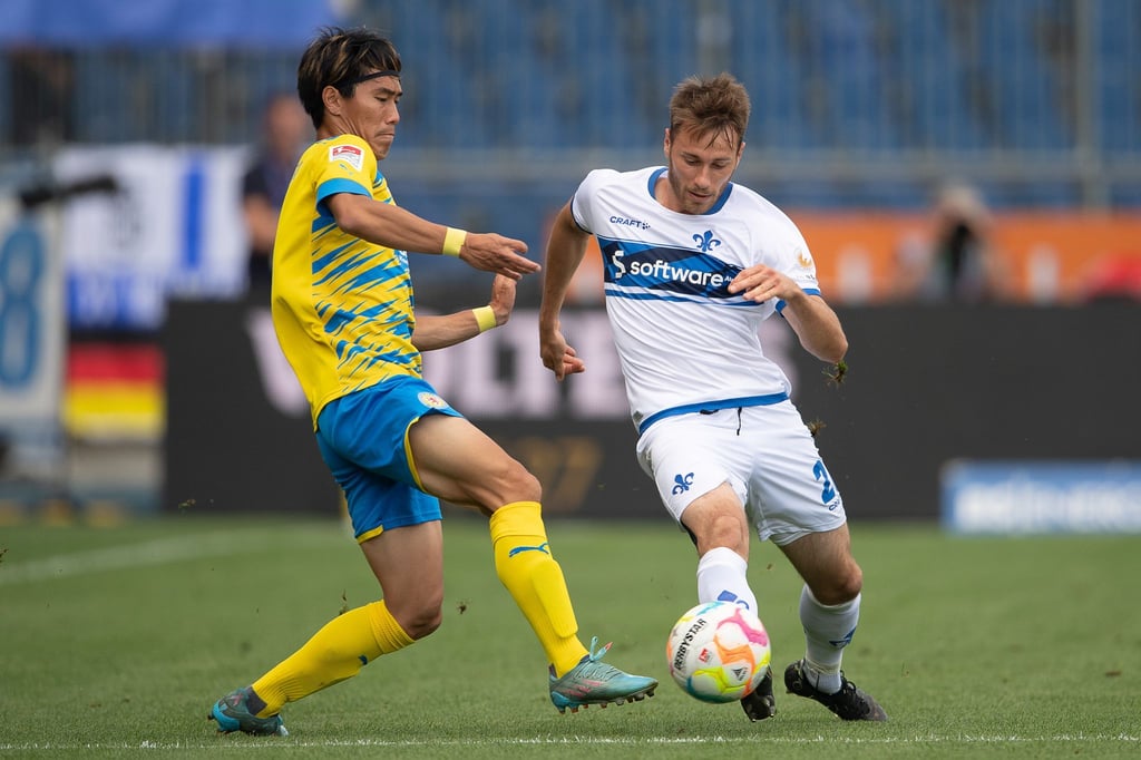 Darmstadts Matthias Bader (r) kommt vor dem Braunschweiger Keita Endo an den Ball.