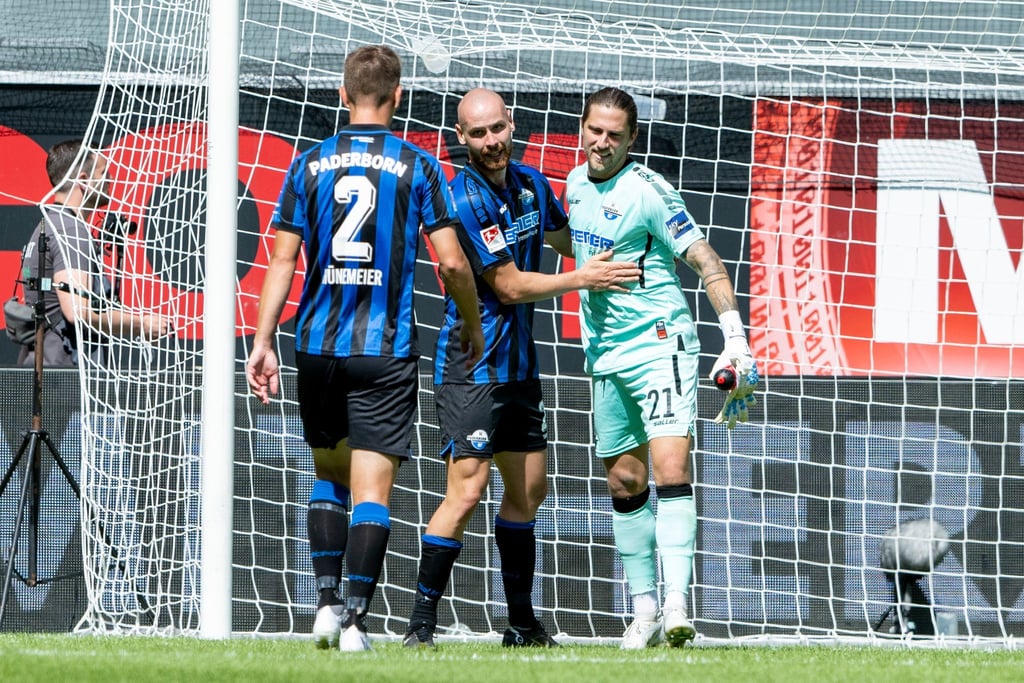 Paderborns Uwe Hünemeier (l-r), Jannis Heuer und Torwart Jannik Huth jubeln nach dem Schlusspfiff.