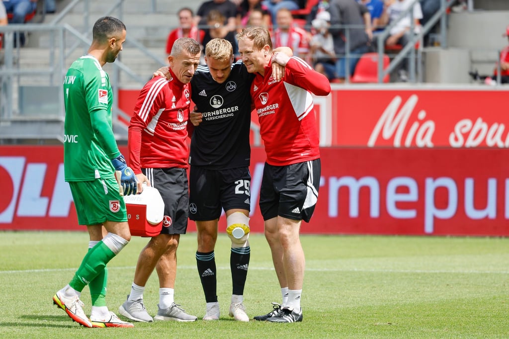 Linksverteidiger Tim Handwerker (2.v.r) wird verletzt vom Platz begleitet.