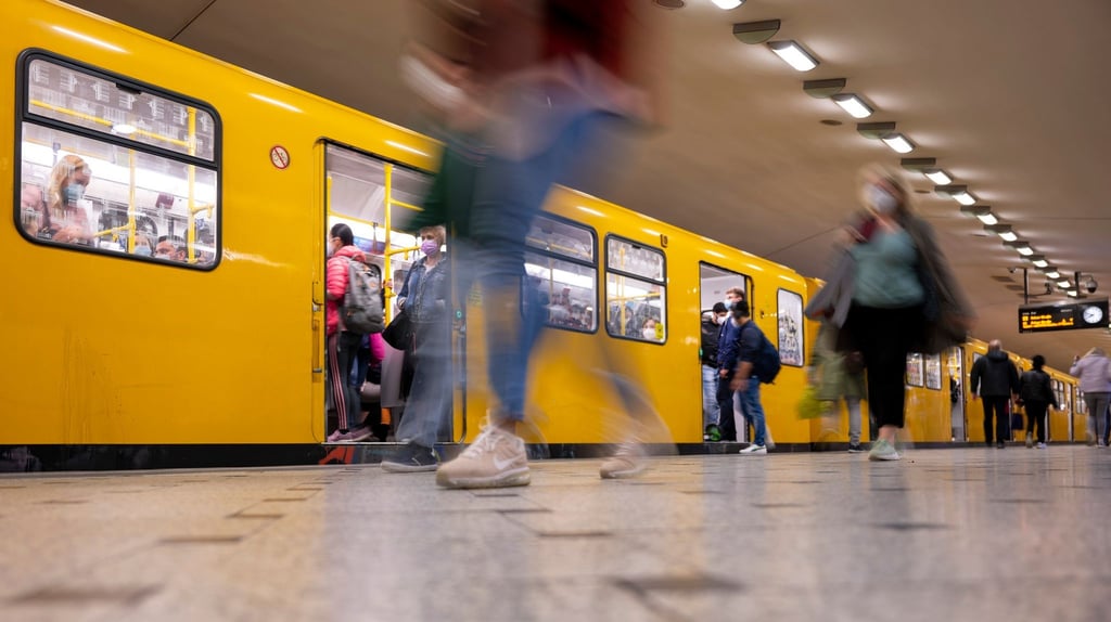 Fahrgäste steigen in einem Berliner U-Bahnhof in eine Bahn.