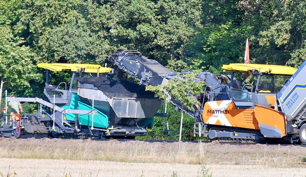 Blick von der Verbindungsstraße nach Kraatz auf die Baustelle: Das Material wird von Lkw in Maschinen gekippt und anschließend gleich verarbeitet. 