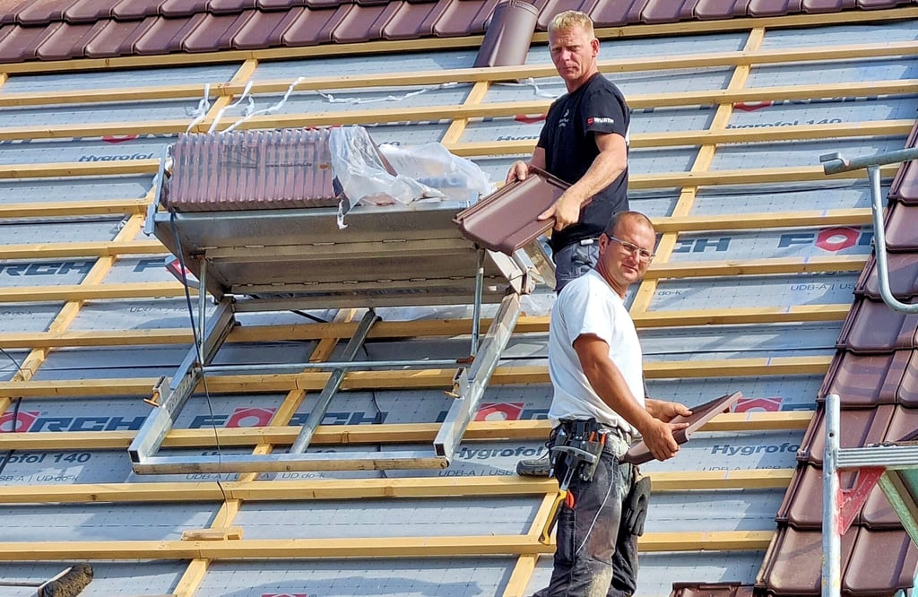 André Butscher und Marco Kemmerich (von links) sind zusammen mit Mirko Schneider (nicht im Bild) derzeit mit einer Dachkomplettsanierung in Neuermark-Lübars beschäftigt.
