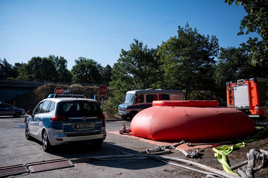 Polizei- und Feuerwehrautos stehen in der Nähe der Brandstelle am Sprengplatz der Berliner Polizei im Grunewald.