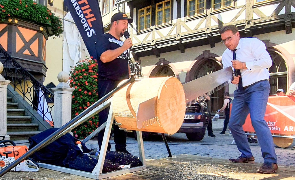 Die Deutsche Timbersports Meisterschaft kommt nach Schierke: Wernigerodes OB Tobias Kascha (rechts, mit Top-Athlet Danny Martin) versucht sich schon mal an der Einmann-Säge. „Das ist schwieriger, als es aussieht“, so sein atemloses Fazit.