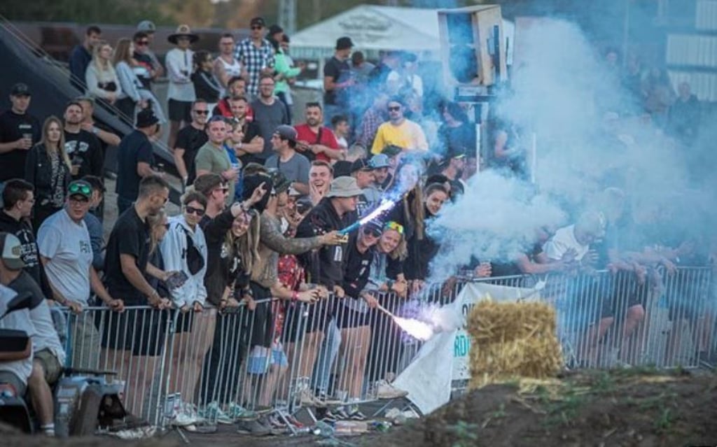 Auf dem Musik- und Motocrossfestival "100 the Challenge" in Borstel schauen Besucher einem Motocrossrennen zu