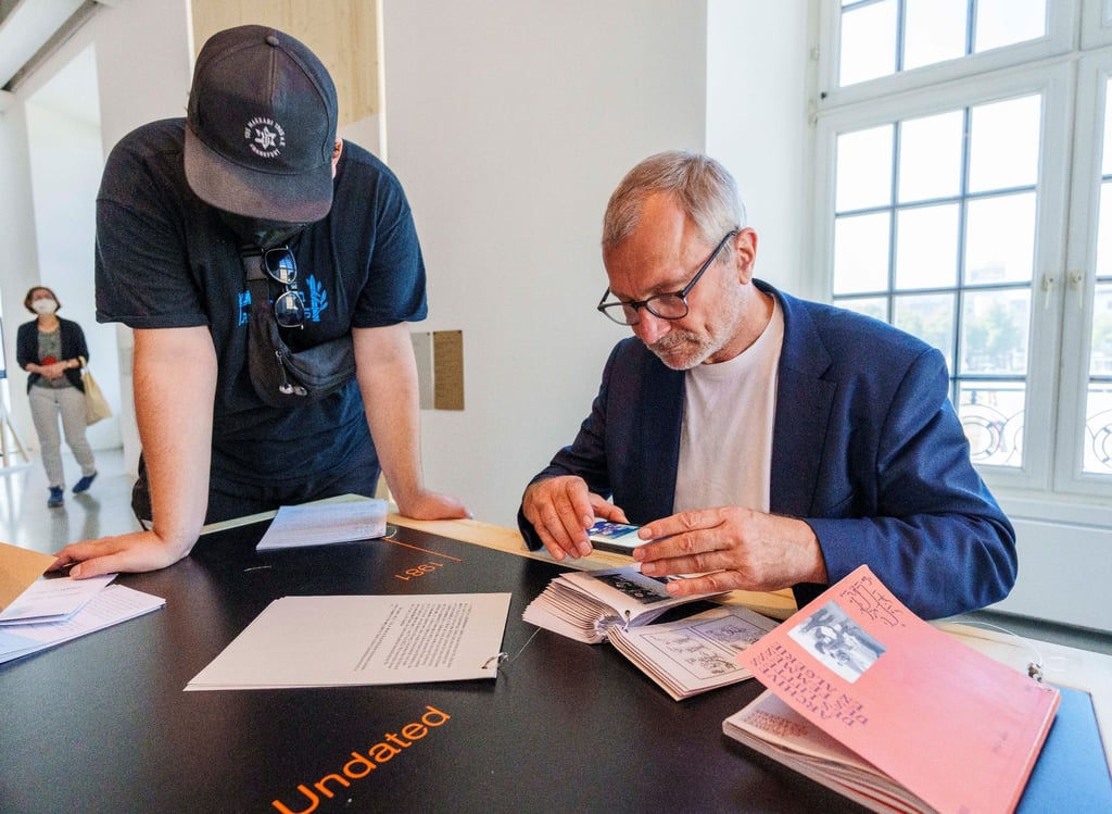 Volker Beck betrachtet die umstrittene Broschüre der Initiative „Archives des luttes des femmes en Algérie“ auf der documenta