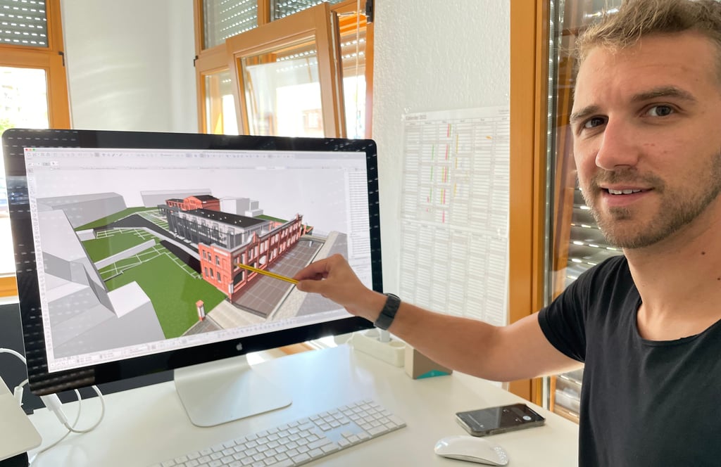 Architekt Marc Maylahn zeigt die visuelle Darstellung des Burger Wohnquartieres mit Alt- und Neubau.