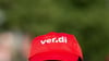Ein Angestellter trägt eine Mütze mit dem Verdi-Logo.