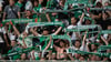 Fans von Werder Bremen stehen mit ihren Schals auf der Tribüne.