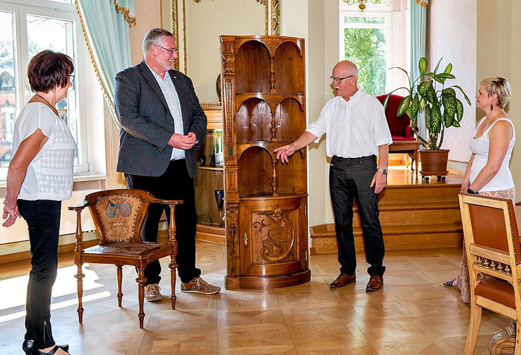Andreas Tomm (2.v.r.) übergibt mit seiner Frau Annegret (l.) die Möbel, Portalschrank sowie Stuhl der Familie Kloss, an Rokäppchen-Chef Mike Eberle im Beisein der Archivarin Stefanie Lenzer.