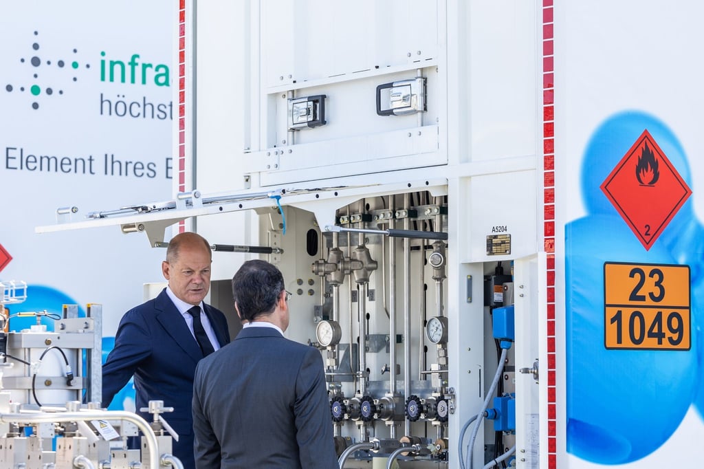 Bundeskanzler Olaf Scholz (links) und Joachim Kreysing (Geschäftsführer Infraserv Höchst) bei der Besichtigung der Wasserstoff-Tankstelle für Züge.