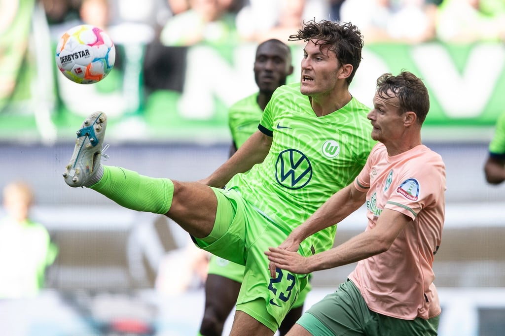 Wolfsburgs Jonas Wind (l) spielt gegen Bremens Christian Groß.