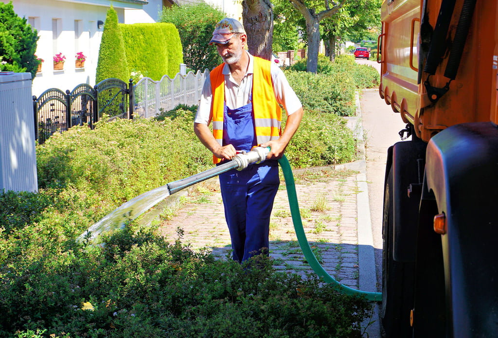 Mark Rölecke, Bundesfreiwilligendienstleistender beim Bauhof Köthen, bewässert städtische Grünflächen.