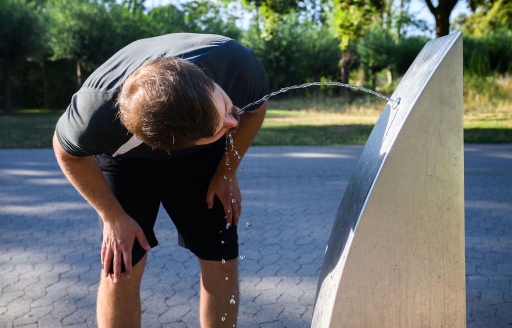 Ein Sportler trinkt Wasser an einem öffentlichen Trinkwasserspender der Stadt Hannover.