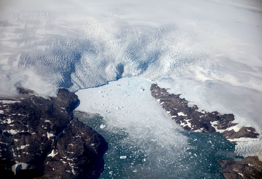 Eisberge brechen von einem Gletscher in einen Fjord in Grönland. Schmelzen die Gletscher und Eisflächen etwa in Grönland, steigen die Meeresspiegel.