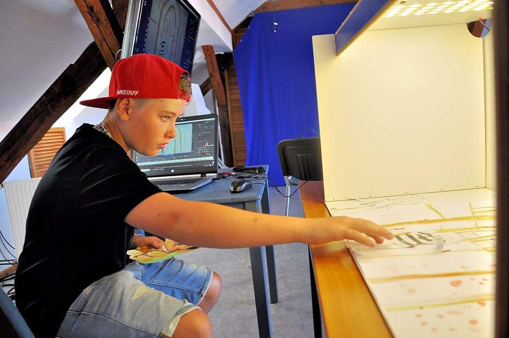 Der 12-jährige Jakob verschiebt im Offenen Kanal Salzwedel an der Trick-Film-Box Papierfiguren für einen Animationsfilm.